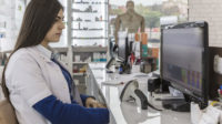 Pharmacist checking prescriptions on a computer