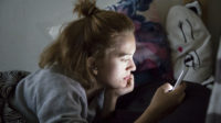 Teenage,Girl,Looks,On,Her,Smartphone,In,Bed,During,The