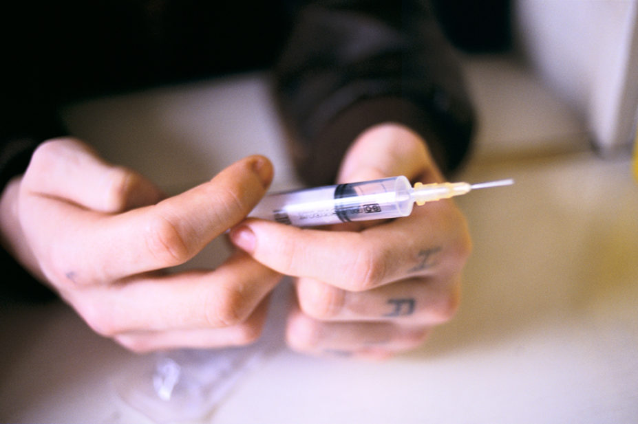 Drug user holding syringe