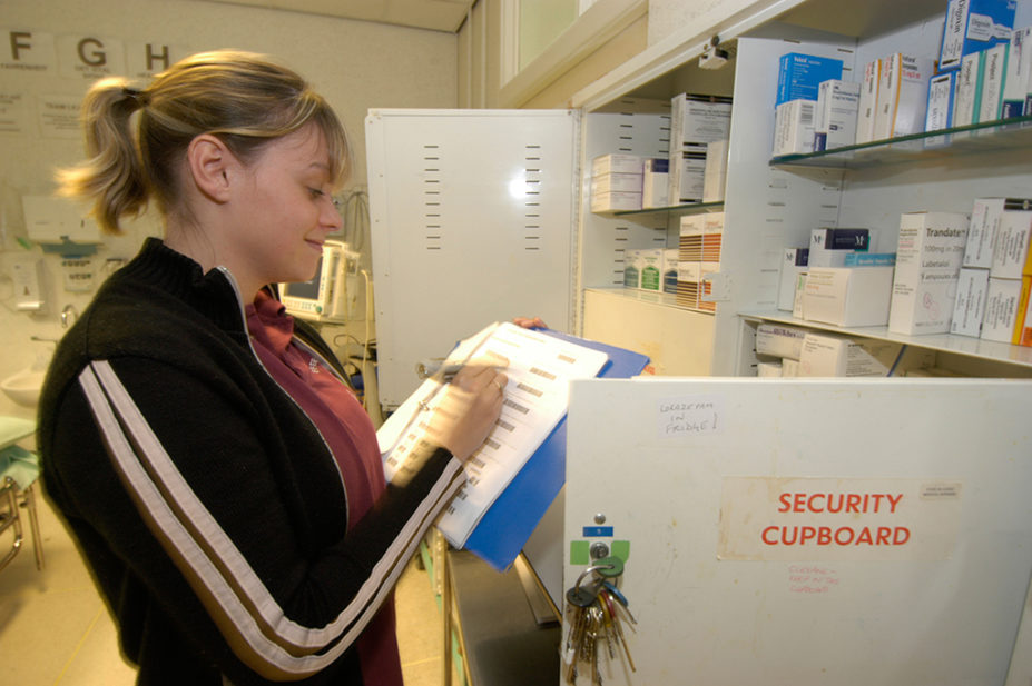 A woman checking prescription drugs in a hospital pharmacy