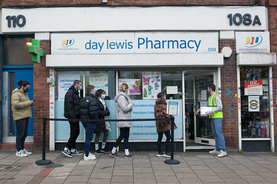 A queue of people outside a pharmacy in London, December 2021