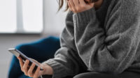 Woman looking at phone, mental health crisis