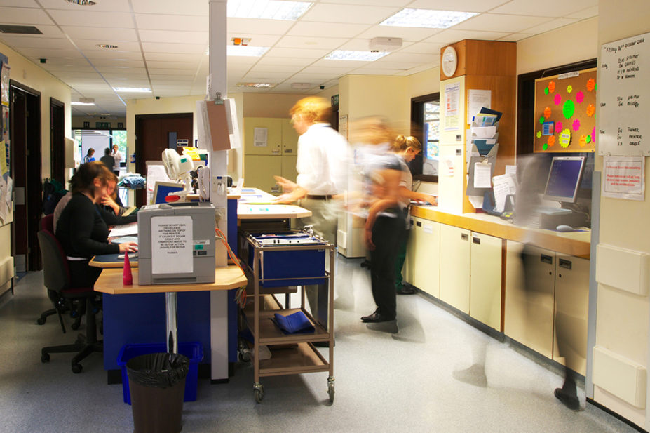 Busy UK NHS hospital ward, with doctors and nurses rushing about