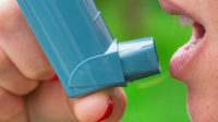 woman using metred dose inhaler