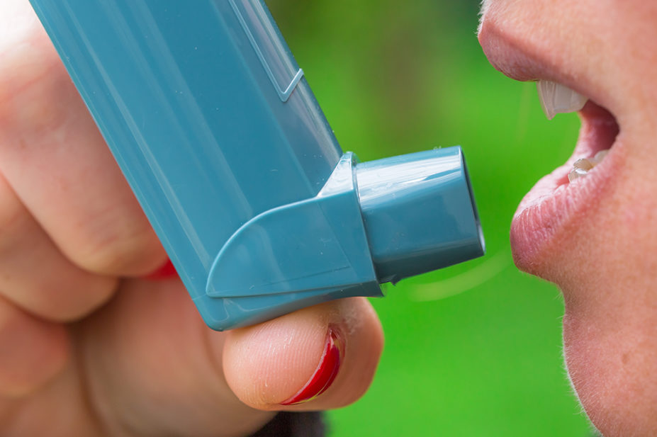 woman using metred dose inhaler