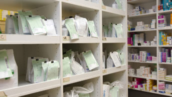 NHS prescriptions on a shelf waiting for collection in a pharmacy