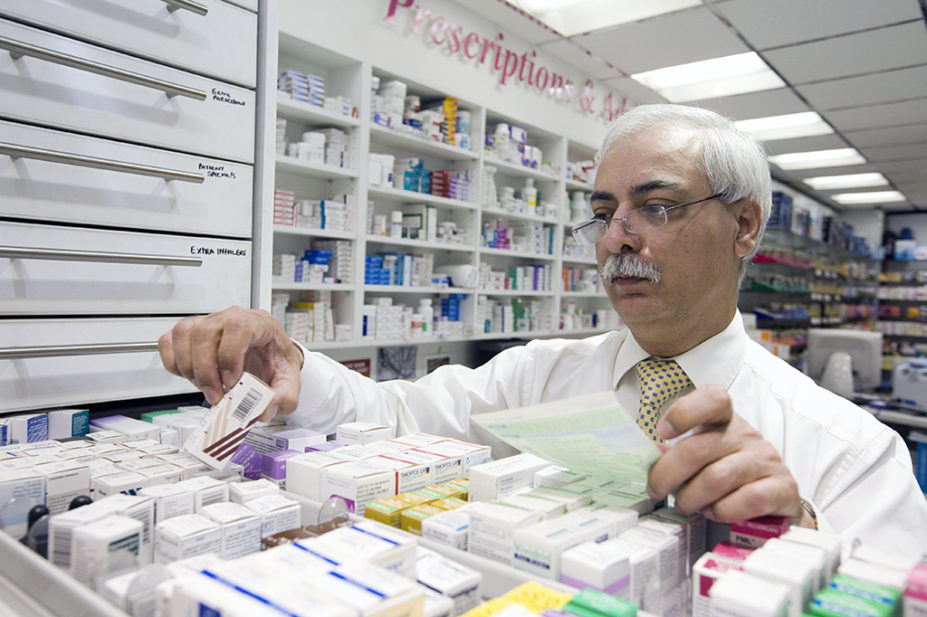 pharmacist looking in drawer for prescription medicine