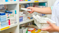 pharmacist taking medicines off shelf
