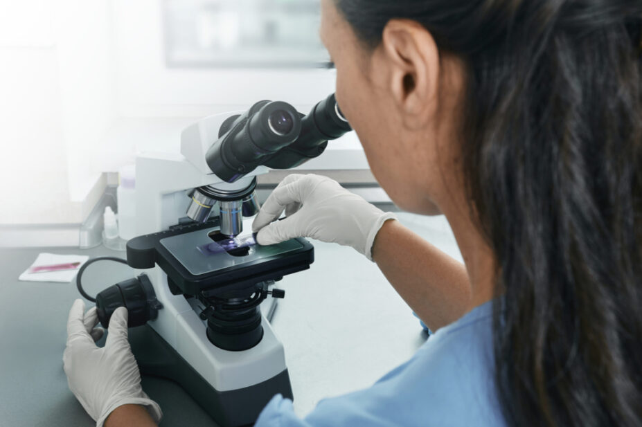 woman looking at slide under microscope