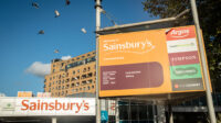 Photo of Sainsburys supermarket on Cromwell Road, Kensington with advertisements for its in-store LloydsPharmacy, Argos, Timpson and Specsavers