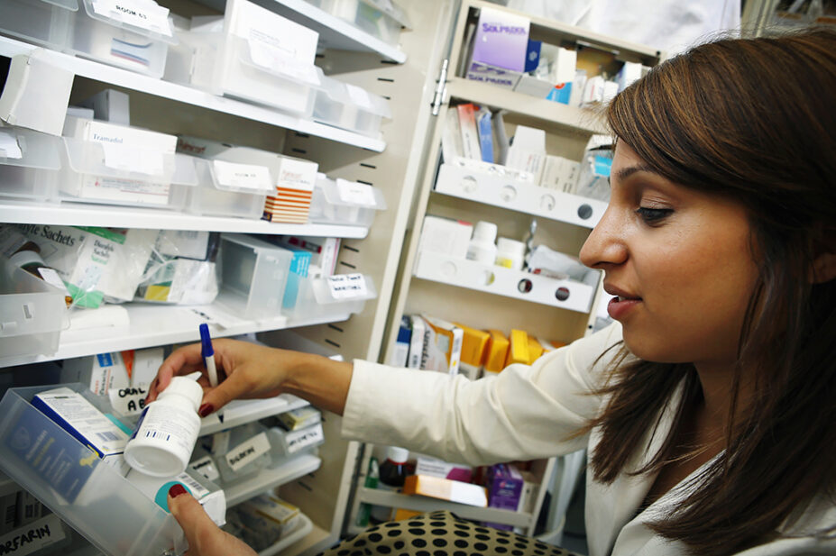 Young pharmacist selecting medication to fill a prescription