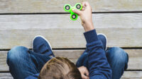 Child playing with fidget spinner outdoors