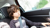 child sat in car looking down