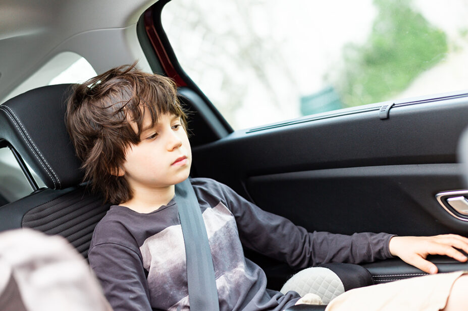 child sat in car looking down
