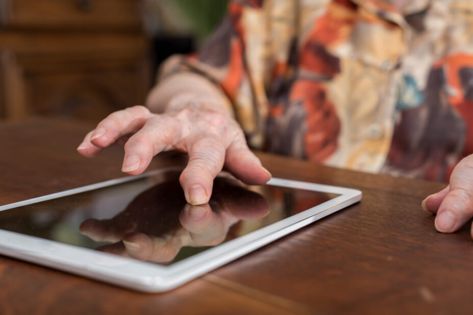 Old woman using a tablet at home