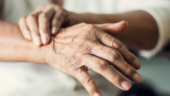 older person holding wrist