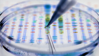 Conceptual genetic research image – pipette adding a sample to a petri dish with a DNA