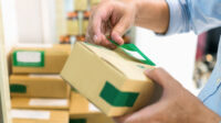 person taping parcel