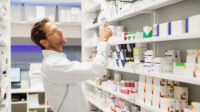pharmacist looking for medicines on shelf