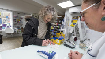 Woman collecting a prescription at a pharmacy
