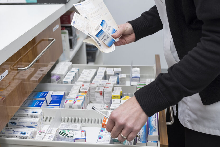 pharmacist getting medicines from drawer for prescription