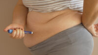Woman injecting herself in stomach