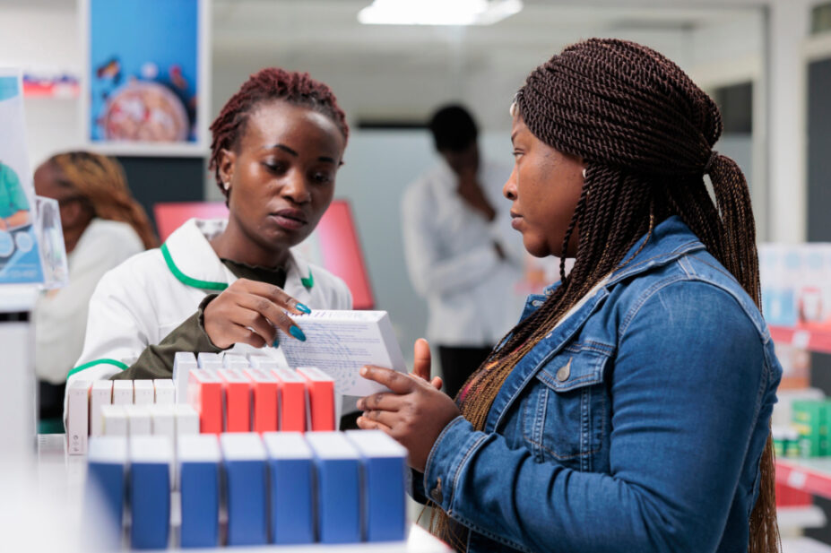 Pharmacist showing customer medicines in pharmacy