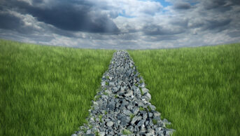 Conceptual image of a bumpy path made of rough rocks disappearing into the distance