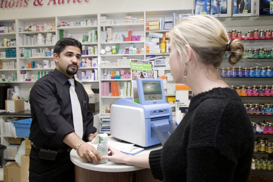 Pharmacist handing over a prescription to a customer