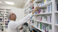 pharmacist looking for medicine on shelves