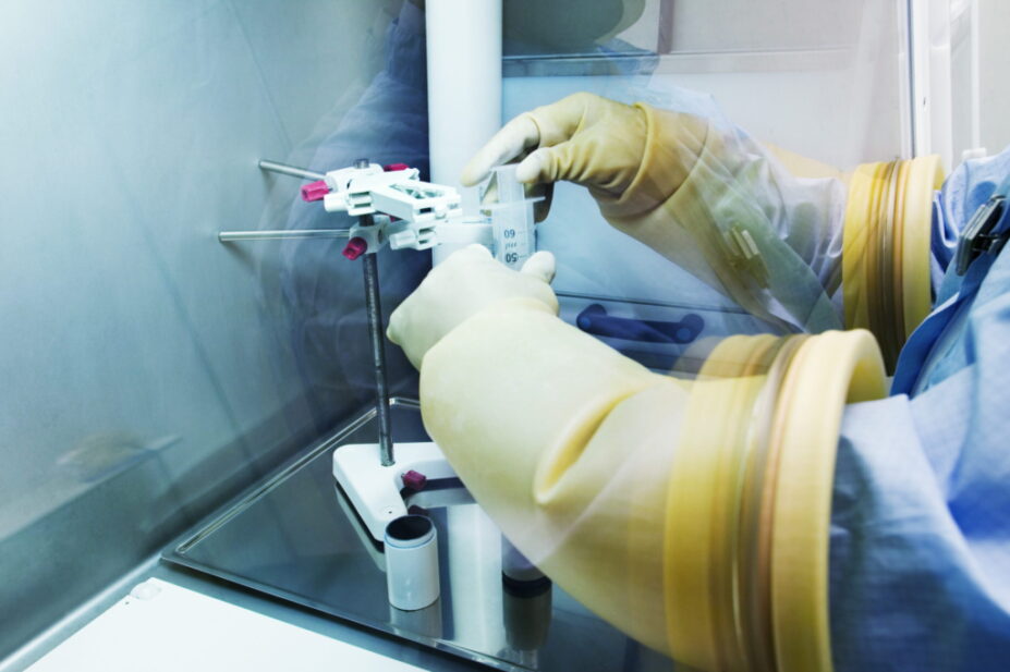 Photo of hands in large rubber gloves inside an aseptic unit