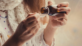 Woman taking cough syrup
