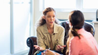woman talking to another woman in therapy setting