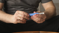 Man self injecting with blue pen