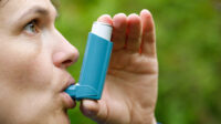 woman using metered dose inhaler