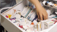 hand reaching into hospital medicines trolley