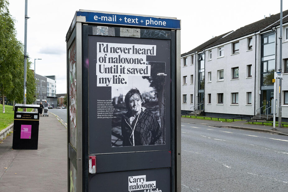 Naloxone campaign messaging on a phone box in Glasgow, Scotland