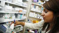 hospital pharmacist selecting medicine from shelf