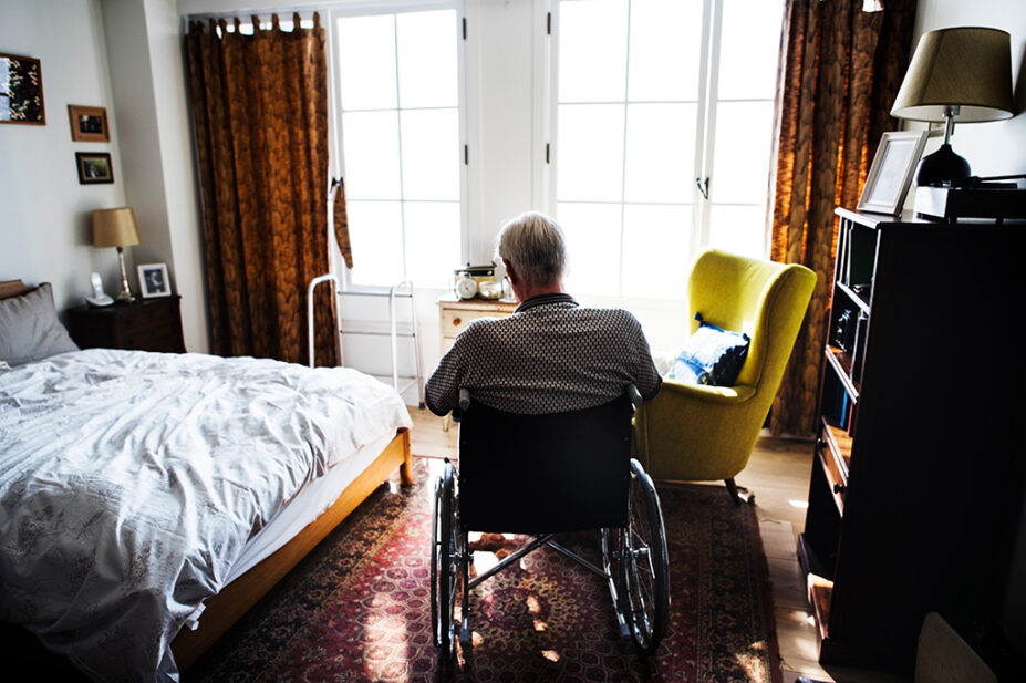 Patient in wheelchair at home in bedroom