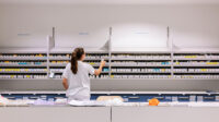 pharmacist checking medicines on shelves