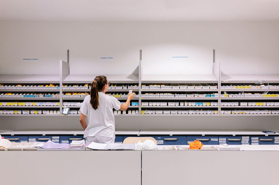 pharmacist checking medicines on shelves