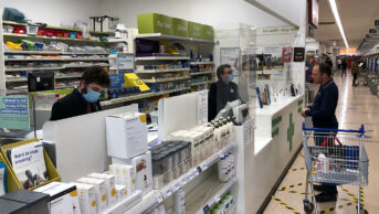 Pharmacists working behind a supermarket pharmacy counter