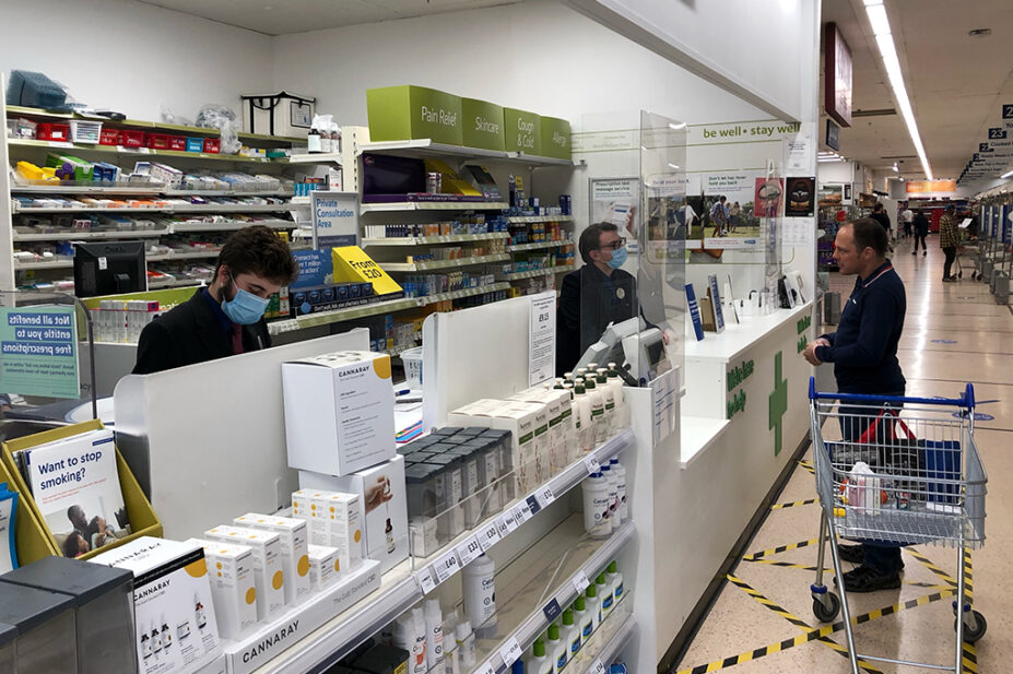 Pharmacists working behind a supermarket pharmacy counter