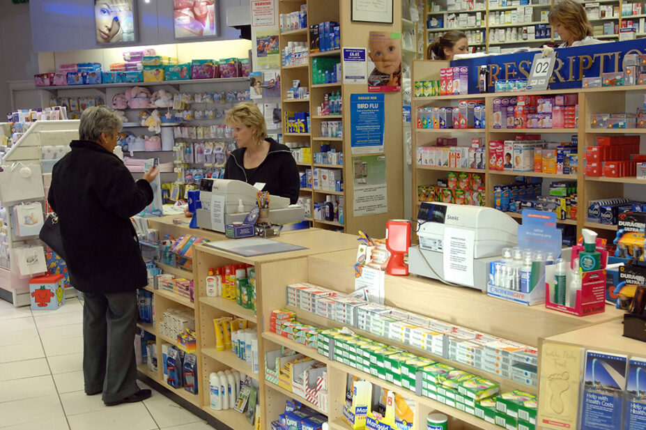 older woman talking to pharmacist at pharmacy counter