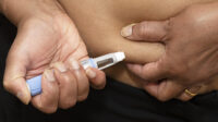 person injecting ozempic into stomach