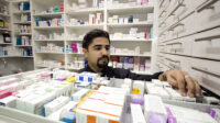 Pharmacist looking through medicines drawer