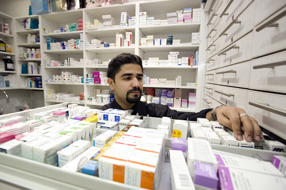 Pharmacist looking through medicines drawer