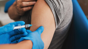 Doctor administering injection in the arm