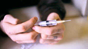 drug user holding injection pen