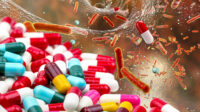 Photo illustration of a cascade of pills calling into a system, with antibiotic resistant bacteria untouched